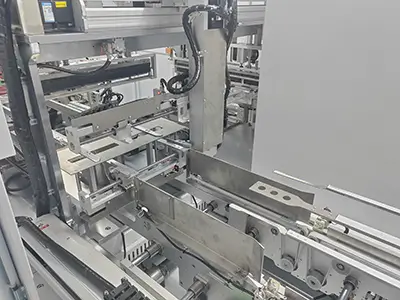 Close-up of key components inside the TY480 shrink-wrap machine, showing stainless-steel guides, pneumatic actuators, and precision conveyors (1)