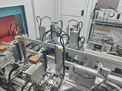 Close-up of key components inside the TY480 shrink-wrap machine, showing stainless-steel guides, pneumatic actuators, and precision conveyors (3)